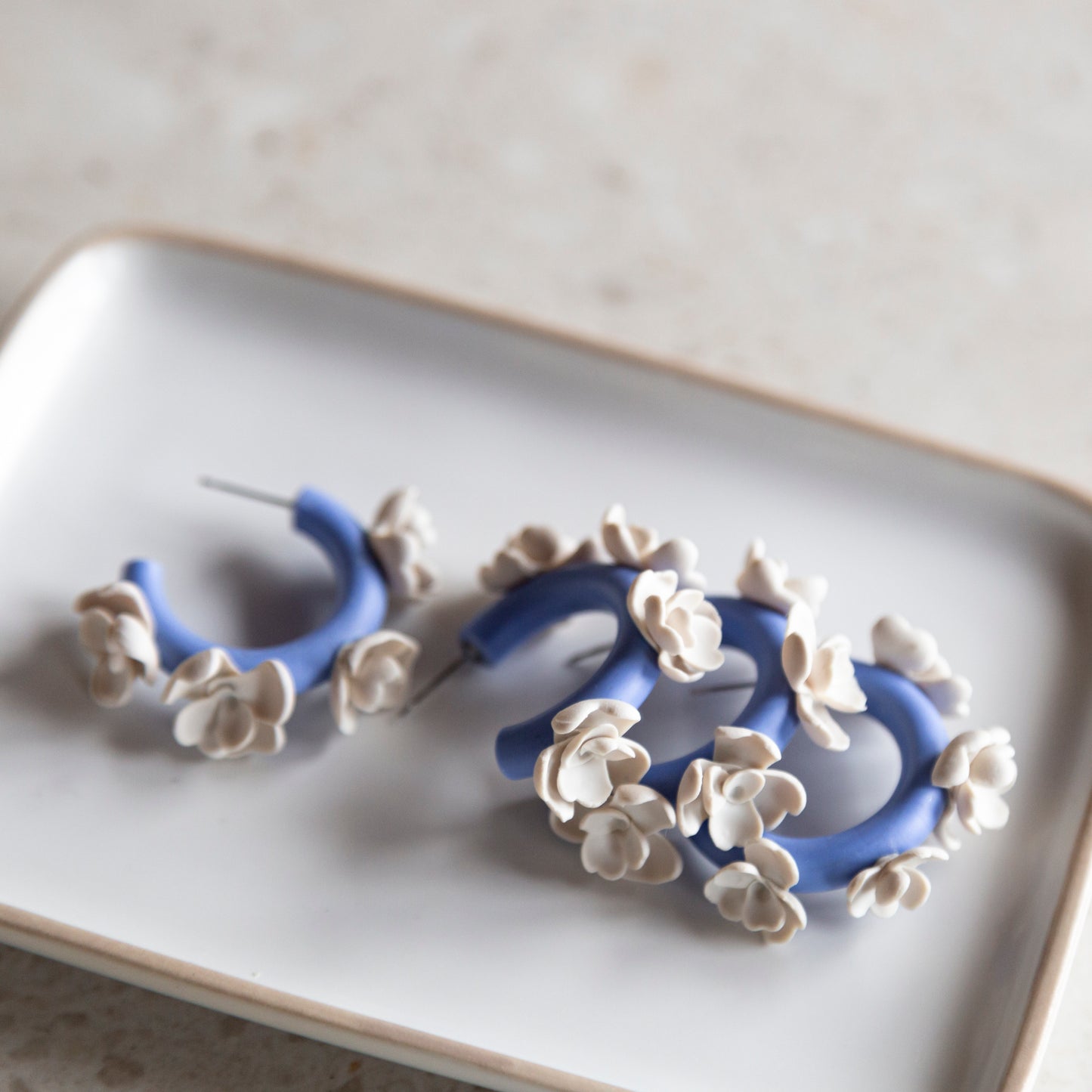 Aros arcilla azules flores blancas