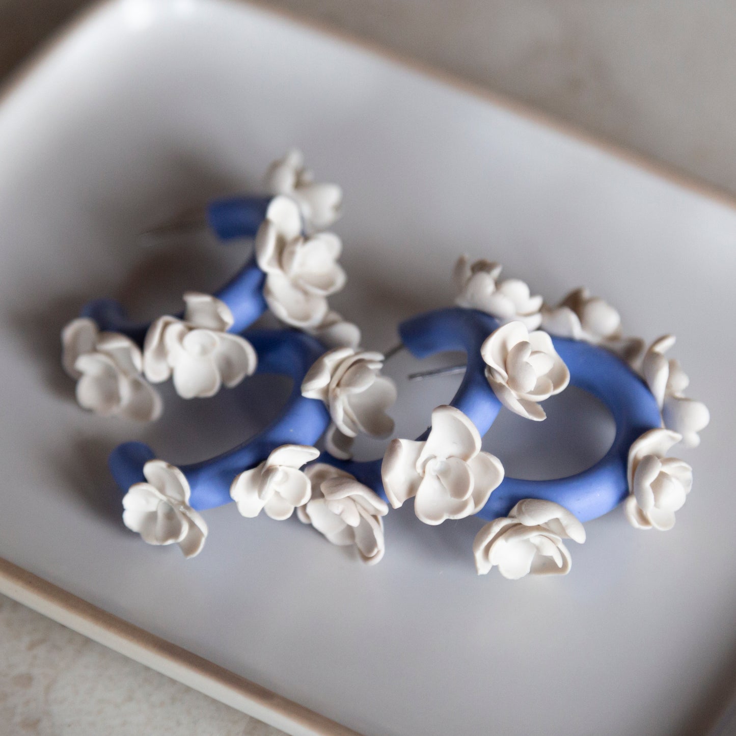Aros arcilla azules flores blancas