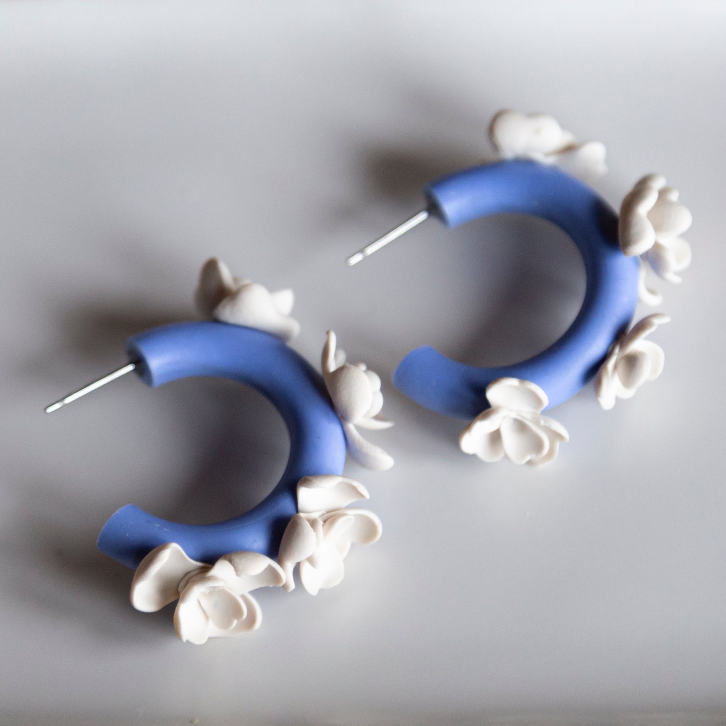 Aros arcilla azules flores blancas