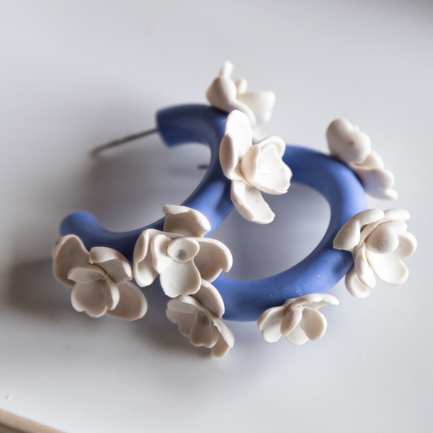 Aros arcilla azules flores blancas