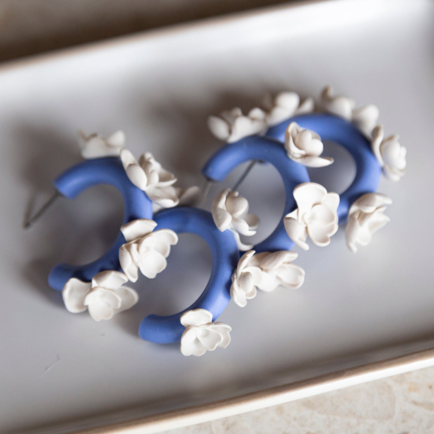 Aros arcilla azules flores blancas
